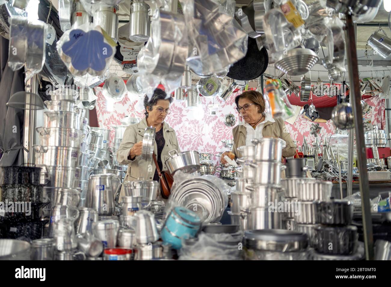 Faro, Portugal - November 23, 2019: Two middle aged women carefully choosing cooking pot from the outdoor stall Stock Photo
