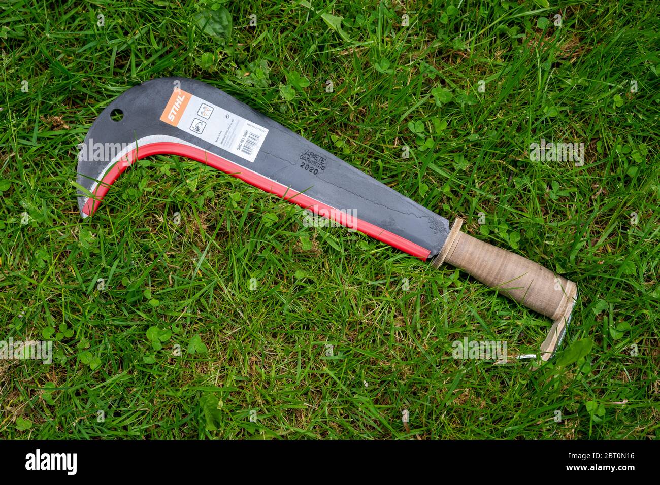 New brush hook made by Stihl laying on the ground before being used. Stock Photo