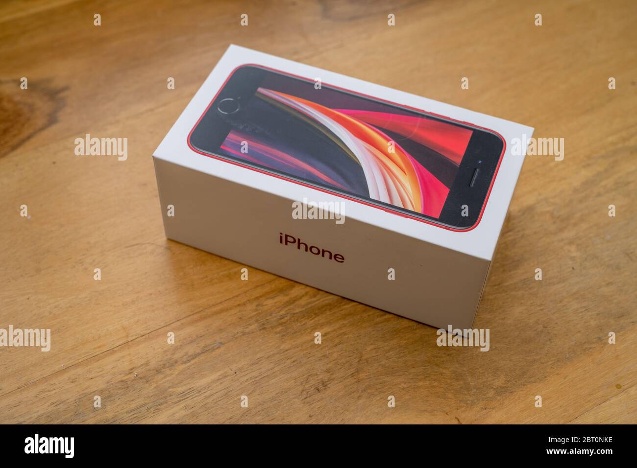 Unopened box for a new Apple iPhone SE sitting on a table. Stock Photo