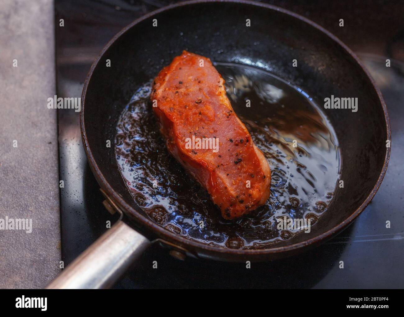 Raw veal steak in a pan while roasting Stock Photo Alamy