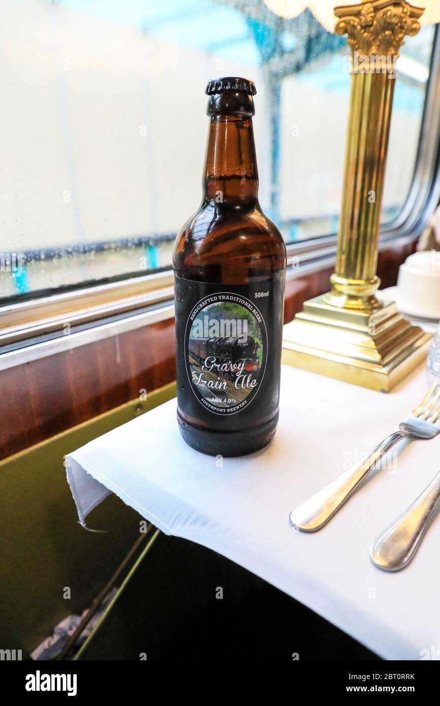 A bottle of real ale called 'Gravy Train Ale' on a table in the dining car of a special train service, England, UK Stock Photo
