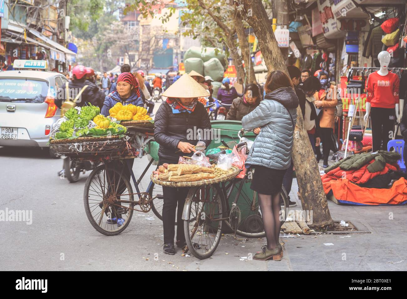 Hoi An, Vietnam - February 7, 2018 : Women selling fruits and vegetables in the early morning in a busy street, Hanoi, Vietnam Stock Photo