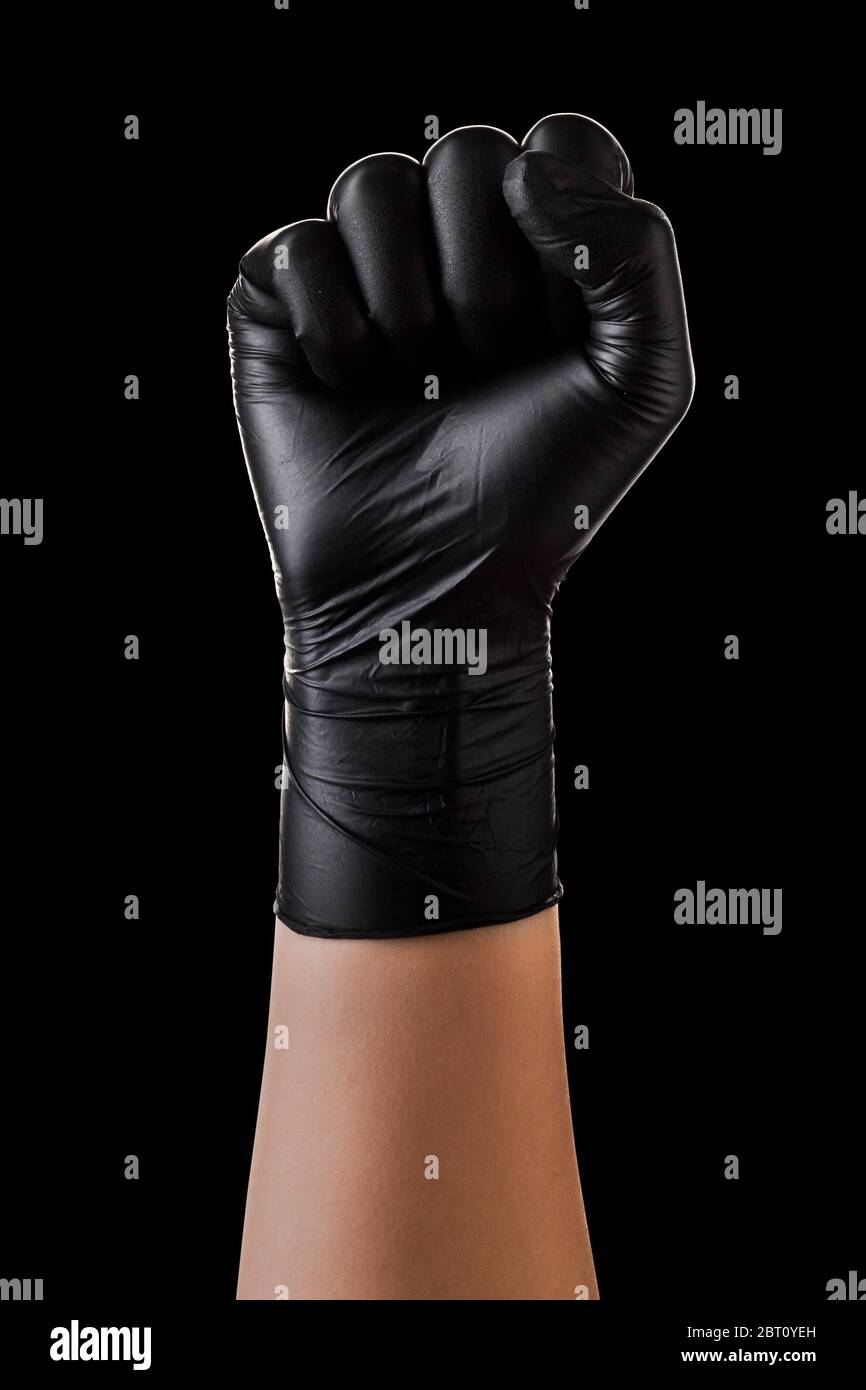 Hand In Black Gloves Showing Clenched Fist Isolated On Black Background