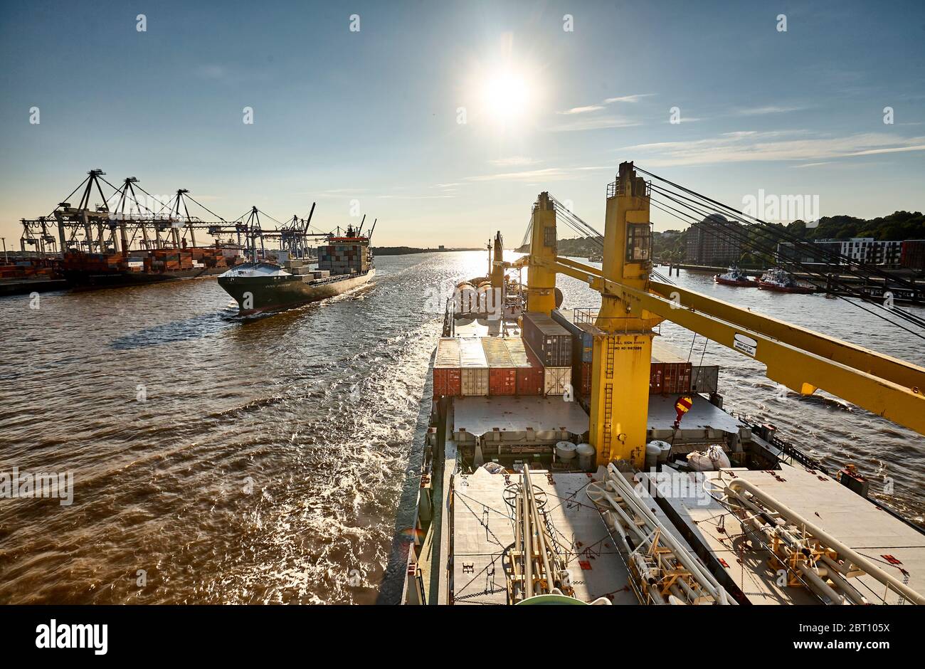 One ship is leaving Hamburg downstream, another one is entering port. Stock Photo