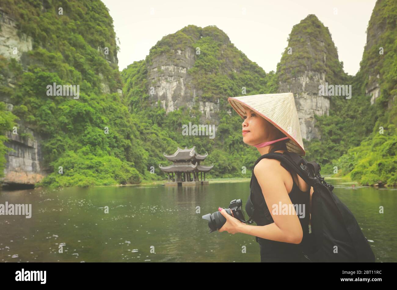 Photographer asian woman taking photos with slr camera professional photography in Ninh Binh, Vietnam Stock Photo