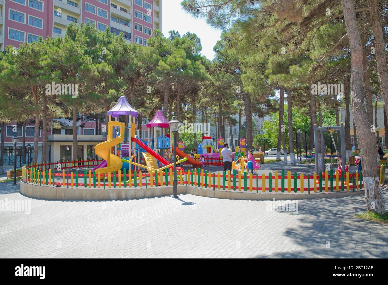 Children kids playground with play equipment outdoor. Kids playground with slides in the park. Pine trees . play ground colorfull big plastic toy set Stock Photo