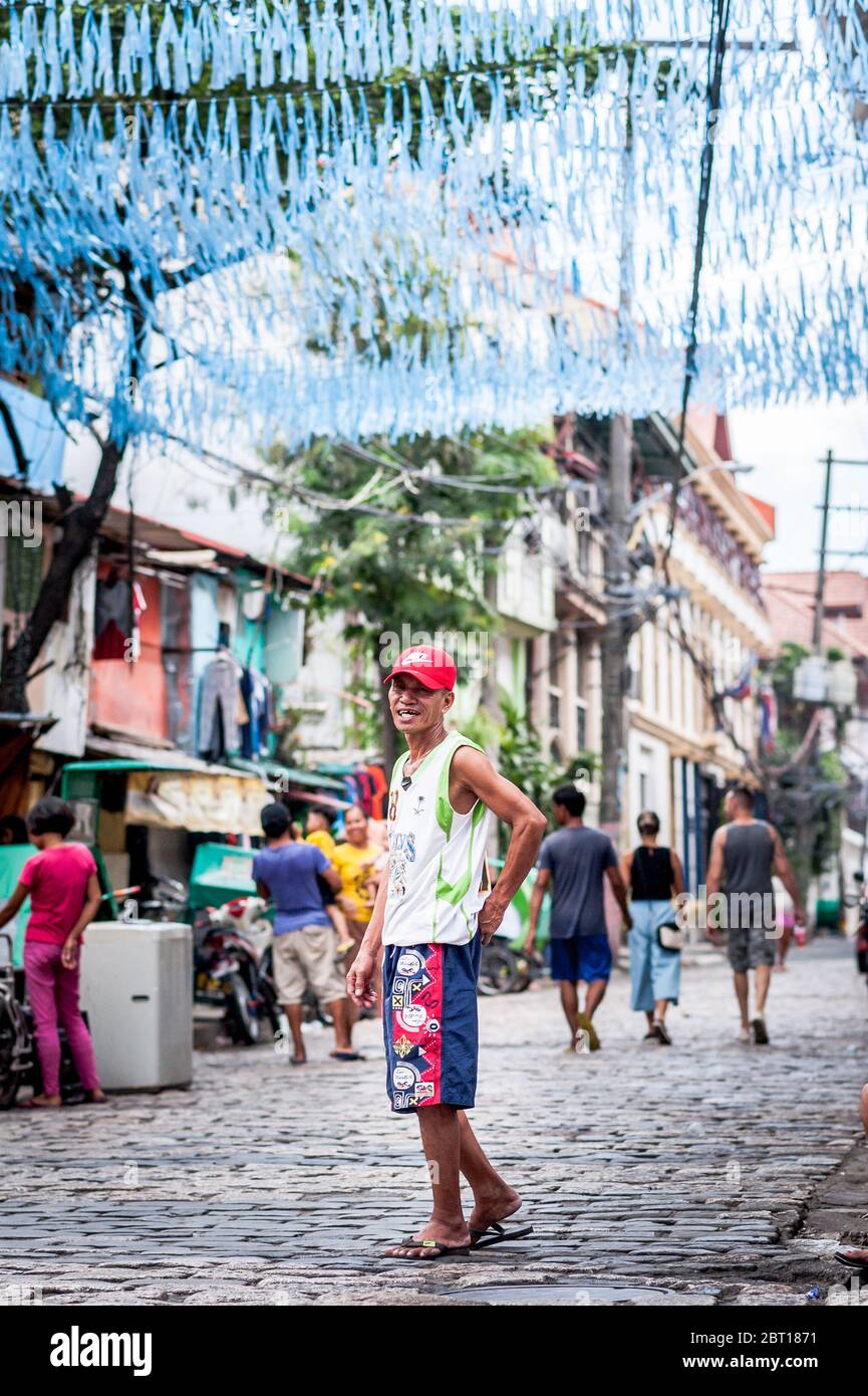 A happy Filipino man jokes with friends in the old walled  city of Intramurous, Manila , The Philippines. Stock Photo