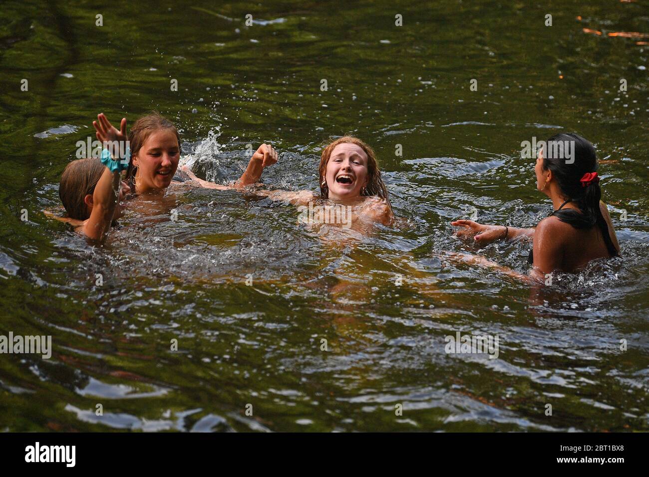 People enjoy the hot weather in River Lea in east London as people