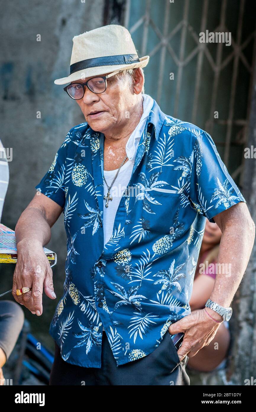 A very stylish gentleman strikes a pose outside his home in the old city of Intramuros, Manila, Philippines. Stock Photo