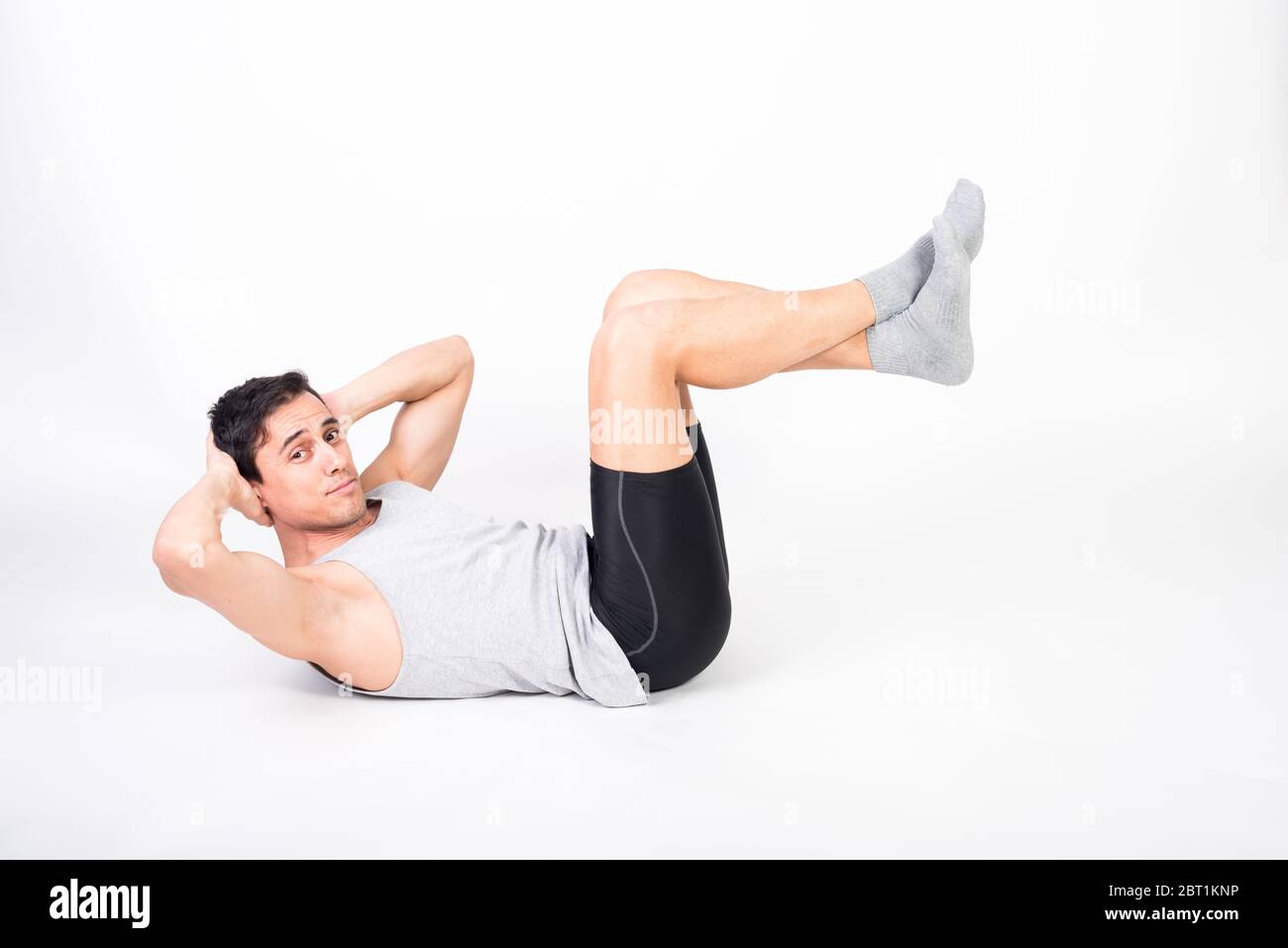 Man in sportswear doing sit ups on the floor. White background full body Stock Photo Alamy