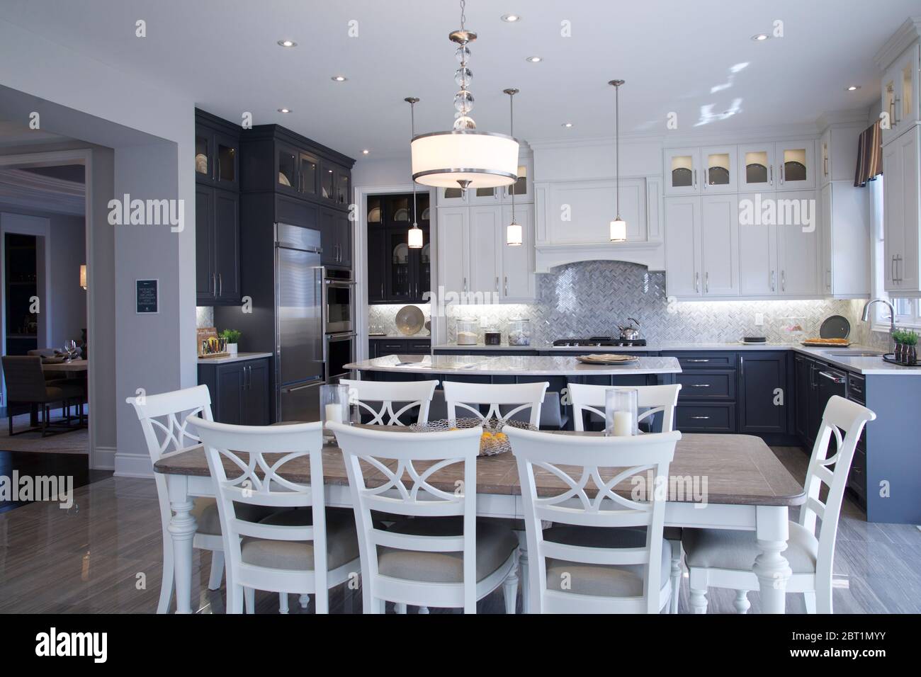 Kleinburg, Ontario / Canada - 08/31/2019: Front view of a newly designed kitchen and a dining table inside a model home Stock Photo