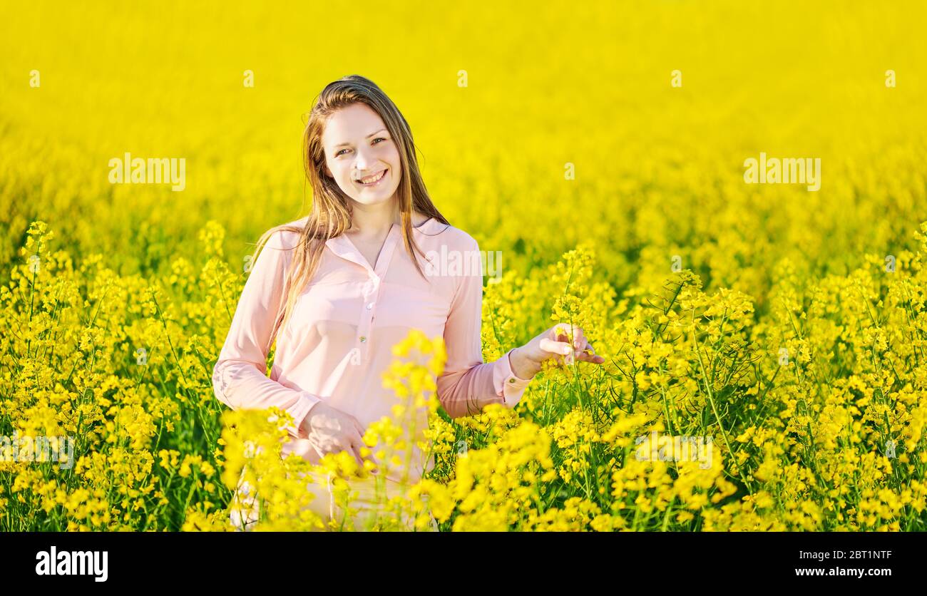 Girl in a blooming rapeseed field, cheerful happiness Stock Photo - Alamy