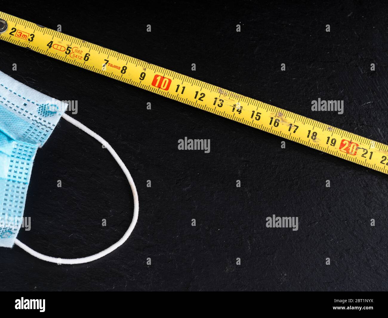 coronavirus icons as facial mask and folding meter on black background ...