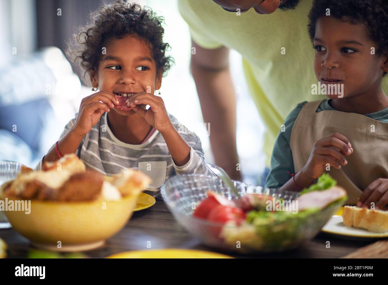 Little children having breakfast. Afro American family at morning. Stock Photo