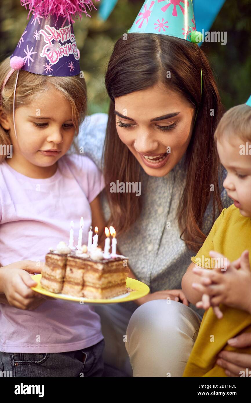 Smiling mother and her child's celebrate children birthday party and blowing candle cake. Stock Photo