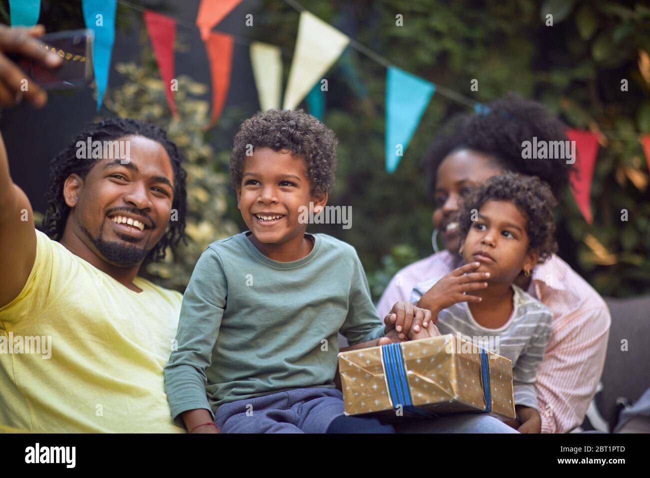 Happy young afro-american family  at birthday party have fun and making selfie. Stock Photo
