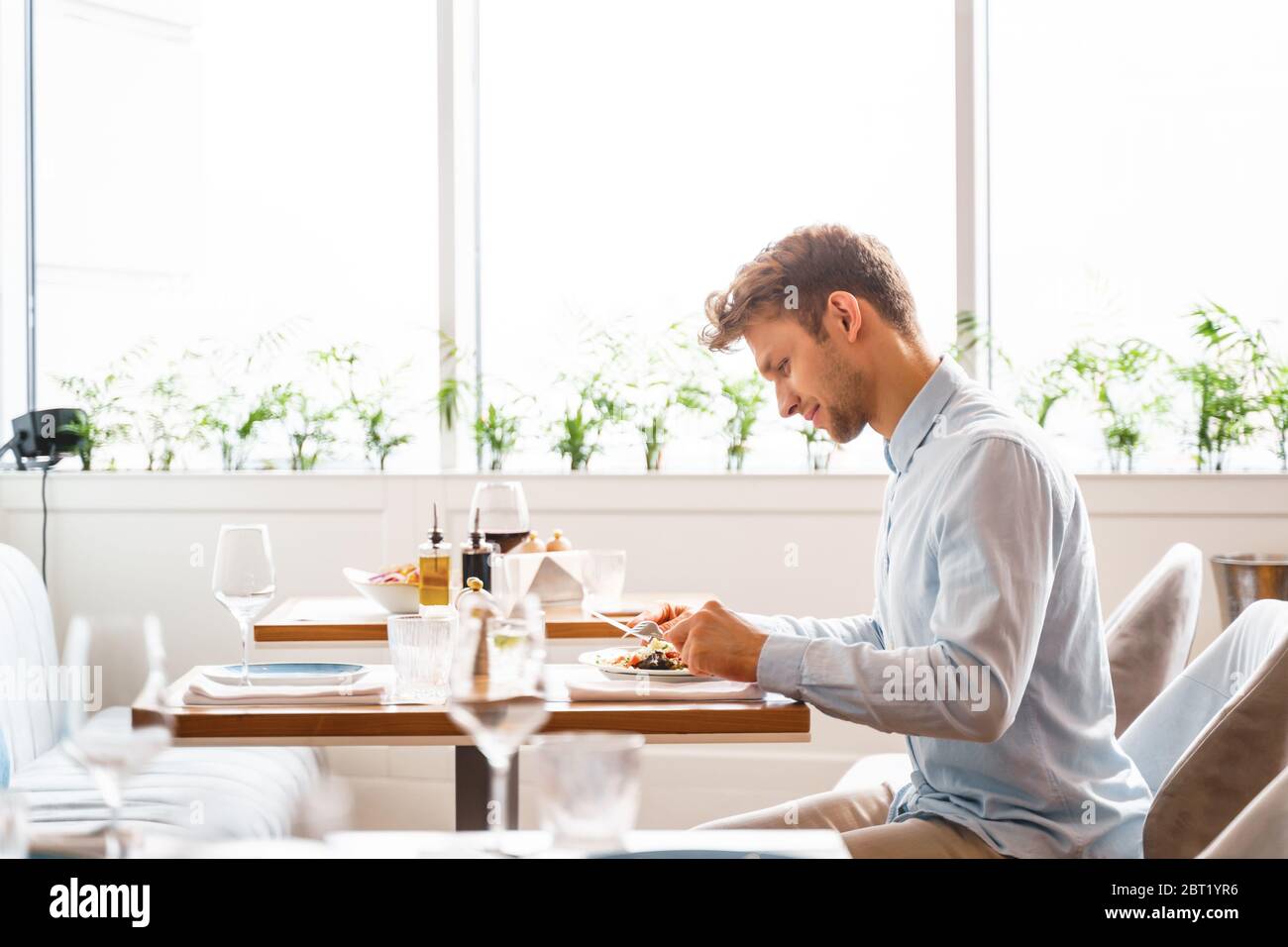Stylish young man having dinner in restaurant Stock Photo - Alamy