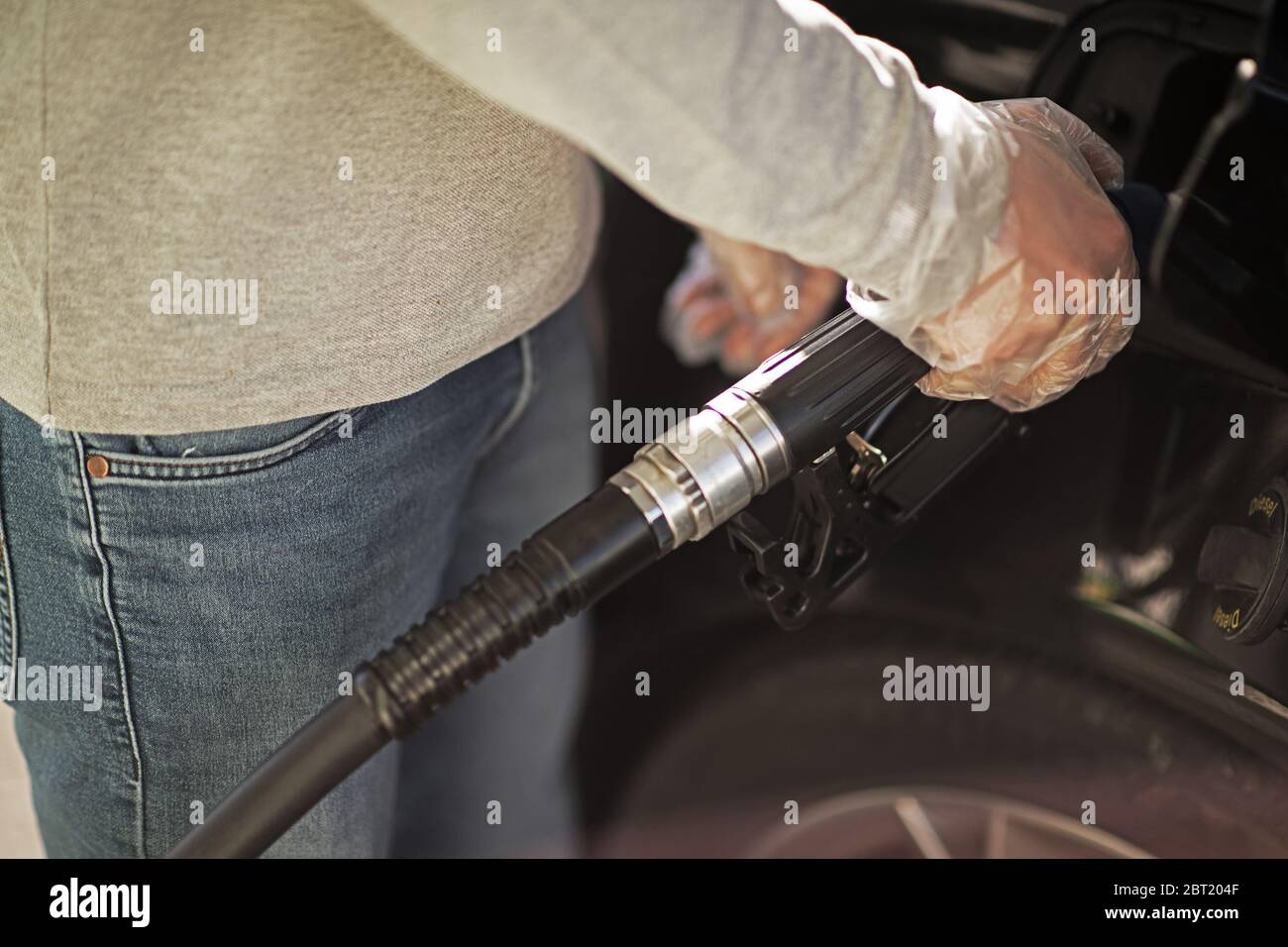Adult Male Wearing Transparent Protective Gloves While Pumping Gasoline