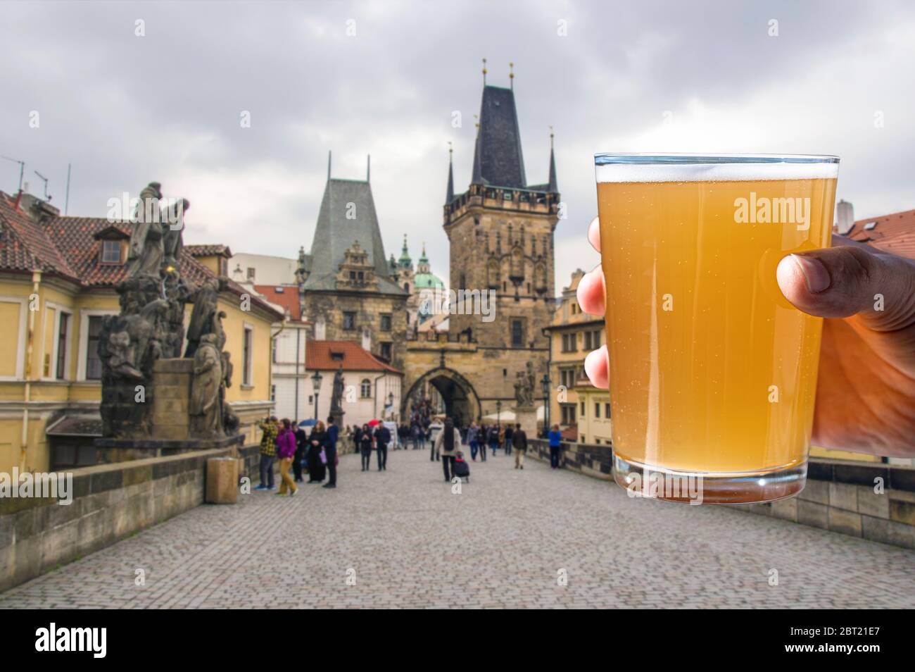 Man holding glass of light beer with view of Charles bridge in Prague, Czech republic Stock Photo