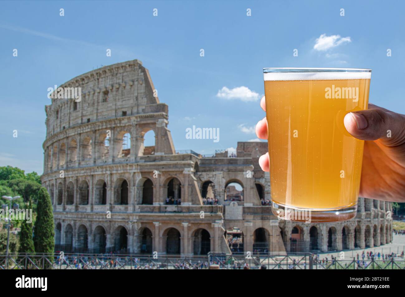 Man holding glass of light beer on Colosseum (Coliseum) background in Rome, Italy Stock Photo