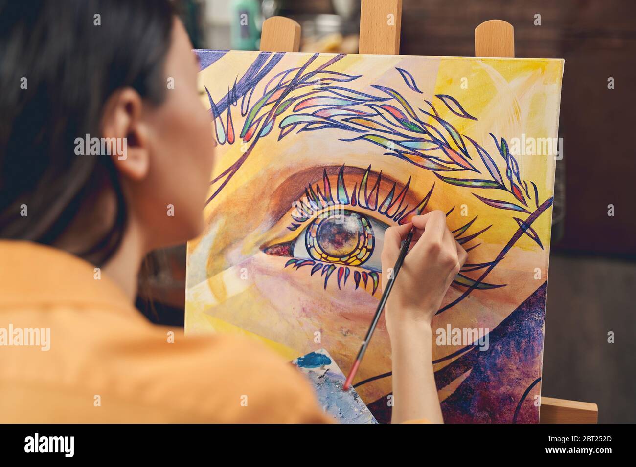 Young woman painting eye on easel in home art studio Stock Photo - Alamy