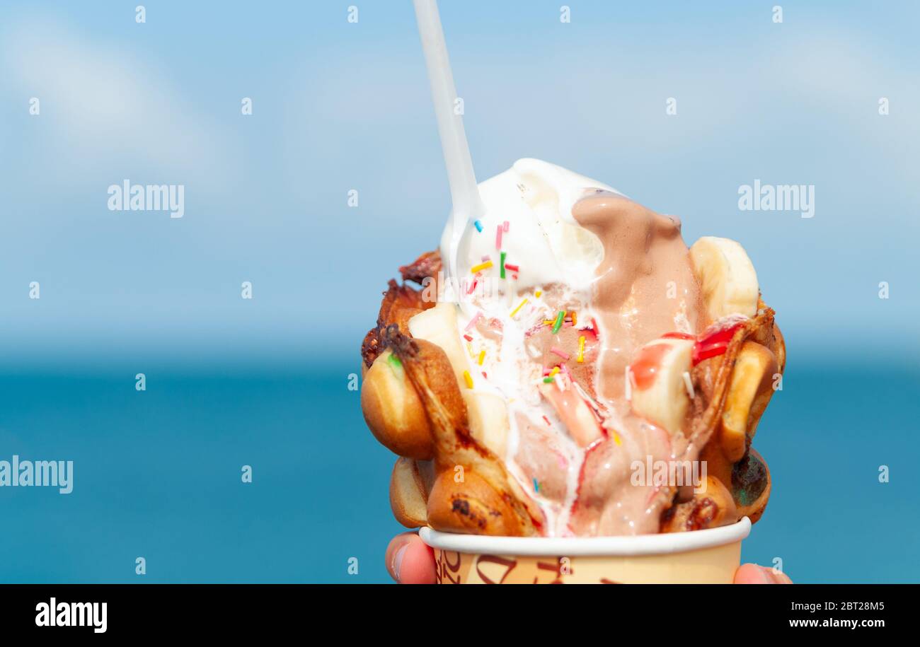 Big ice-cream in Bubble Waffle on a beach. Closeup Stock Photo