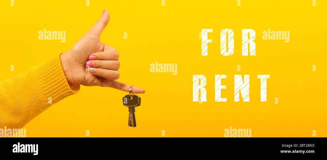 hand holding house keys near inscription for rent, concept rental