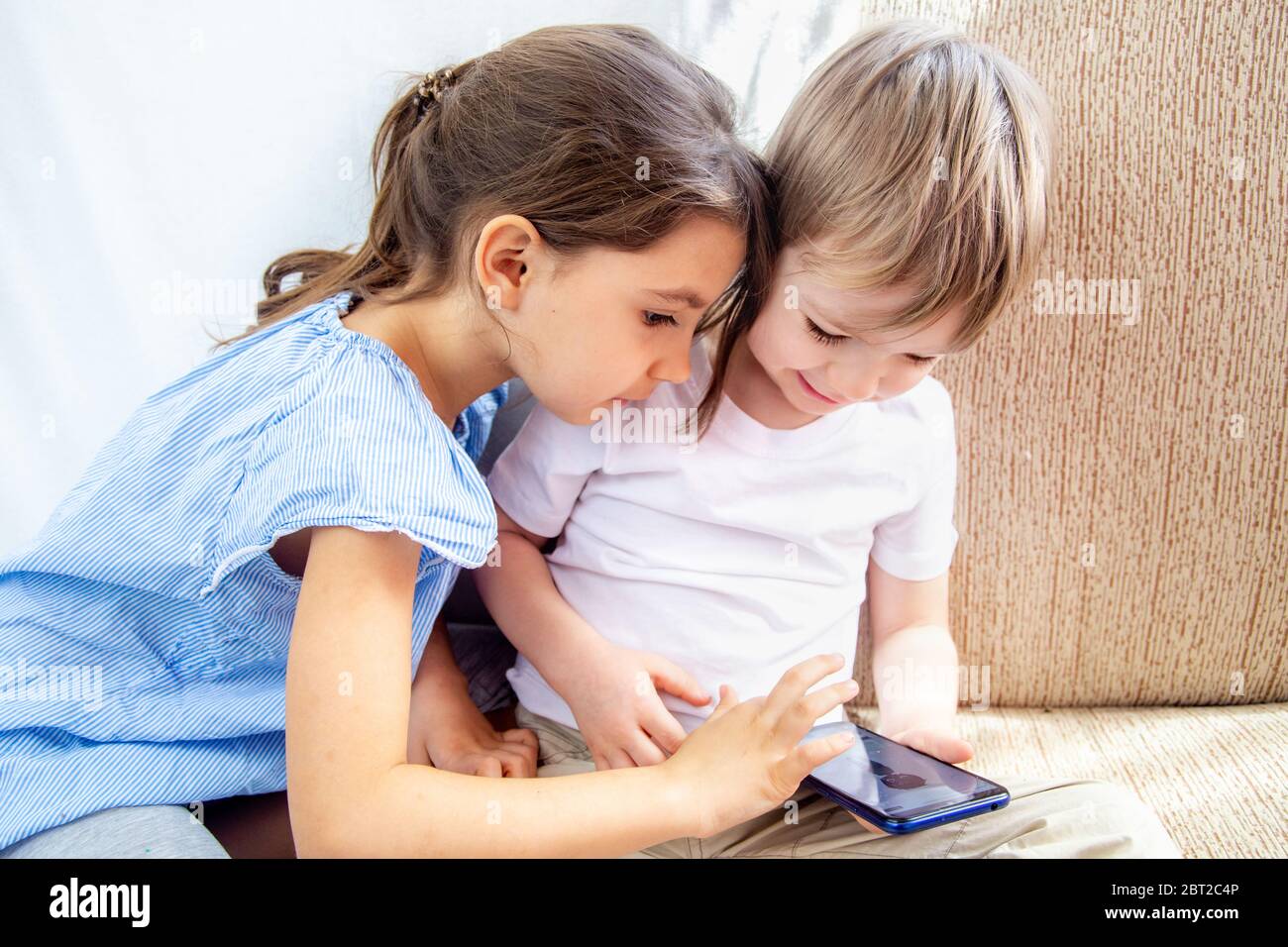 Close Up Siblings Brother And Sister Playing With Tablet Kids Have A Good Time At Home Children Sitting On Sofa Playing With Tablet Kids Play A Stock Photo Alamy