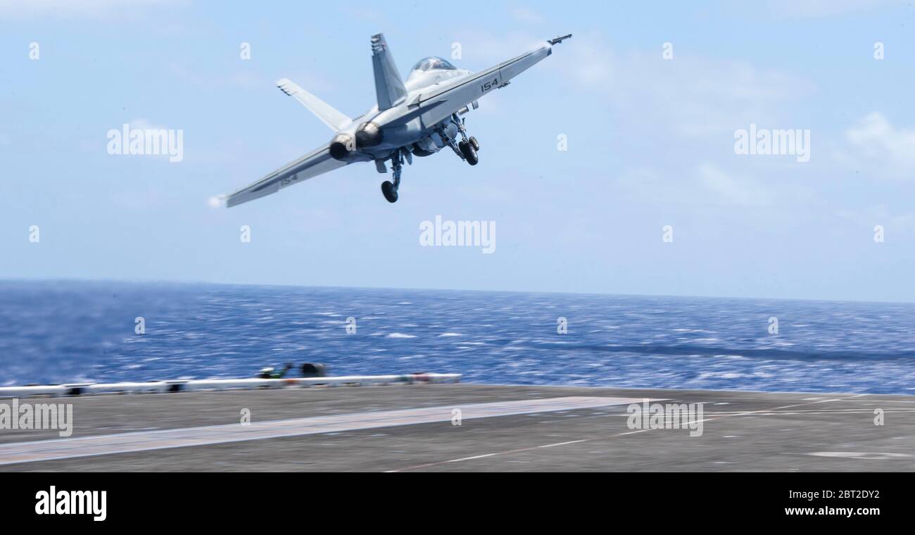 Philippine Sea, United States. 22nd May, 2020. A U.S. Navy F/A-18F Super Hornet fighter aircraft, assigned to the Black Knights of VFA 154, launches from the flight deck of the Nimitz-class aircraft carrier USS Theodore Roosevelt May 22, 2020 in the Philippine Sea. The COVID-negative crew returned from quarantine and the ship has continued their scheduled deployment to the Indo-Pacific. Credit: MCS3 Conner Blake/U.S. Navy/Alamy Live News Stock Photo