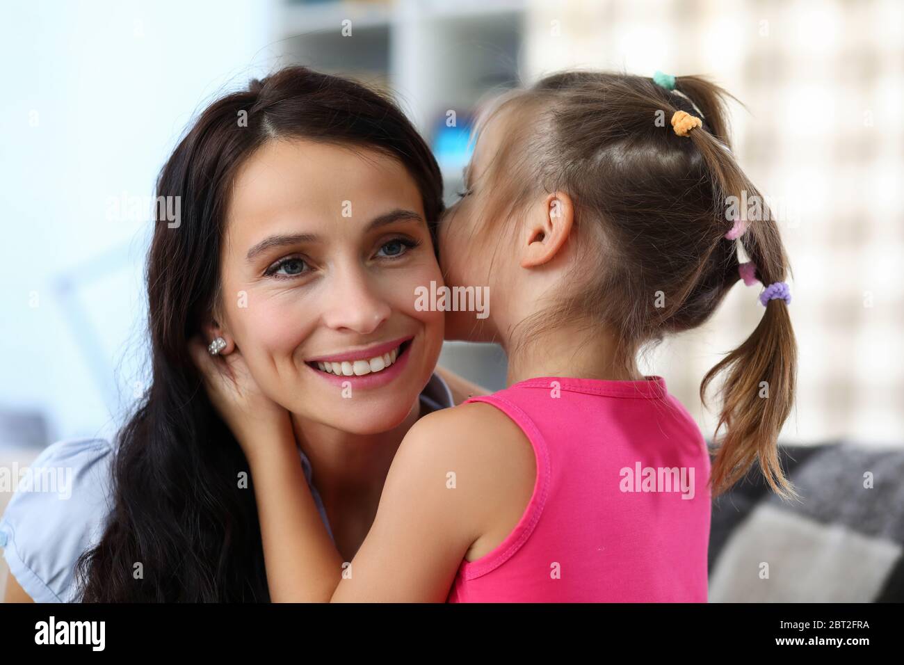 Child hugging cheerful mommy Stock Photo