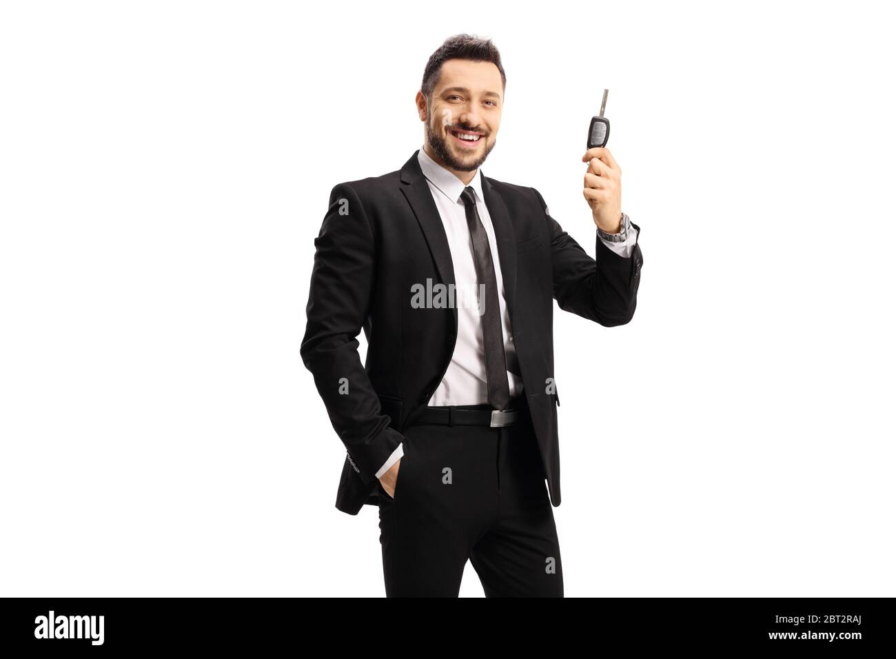 Happy man in a black suit holding a car key isolated on white ...
