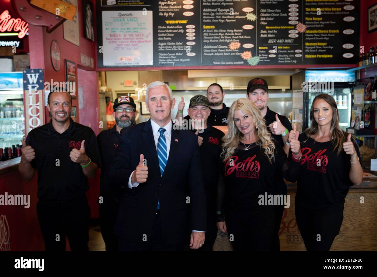 U.S. Vice President Mike Pence poses with Beth Steele, center right, and the staff of Beth’s Burger Bar May 20, 2020 in Orlando, Florida. Pence ate lunch with Florida Gov. Ron DeSantis and both failed to respect social distancing rules and went mask-less. Stock Photo