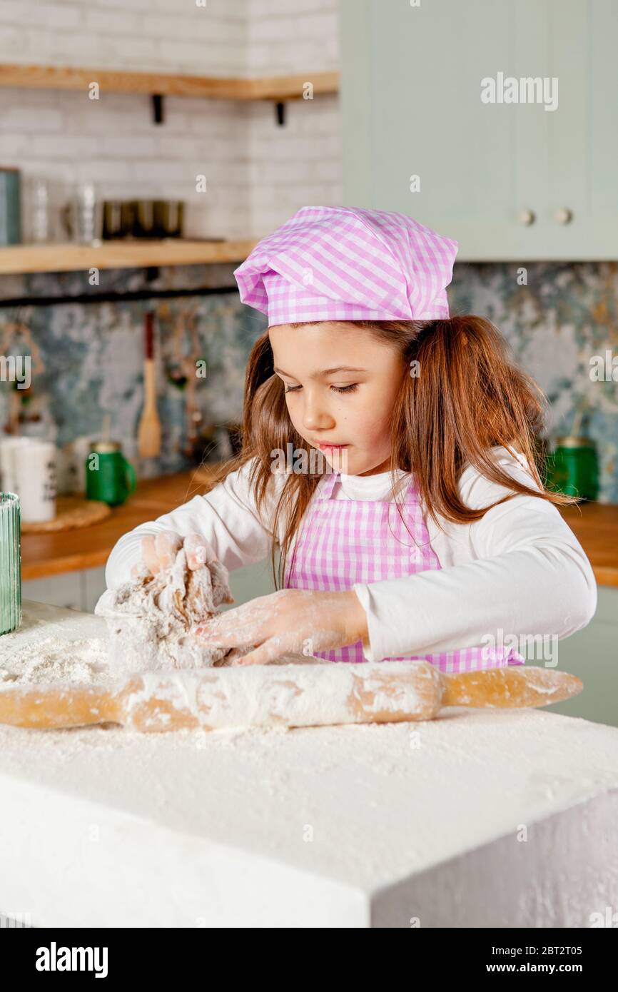 Girl in the kitchen kneads dough Stock Photo - Alamy