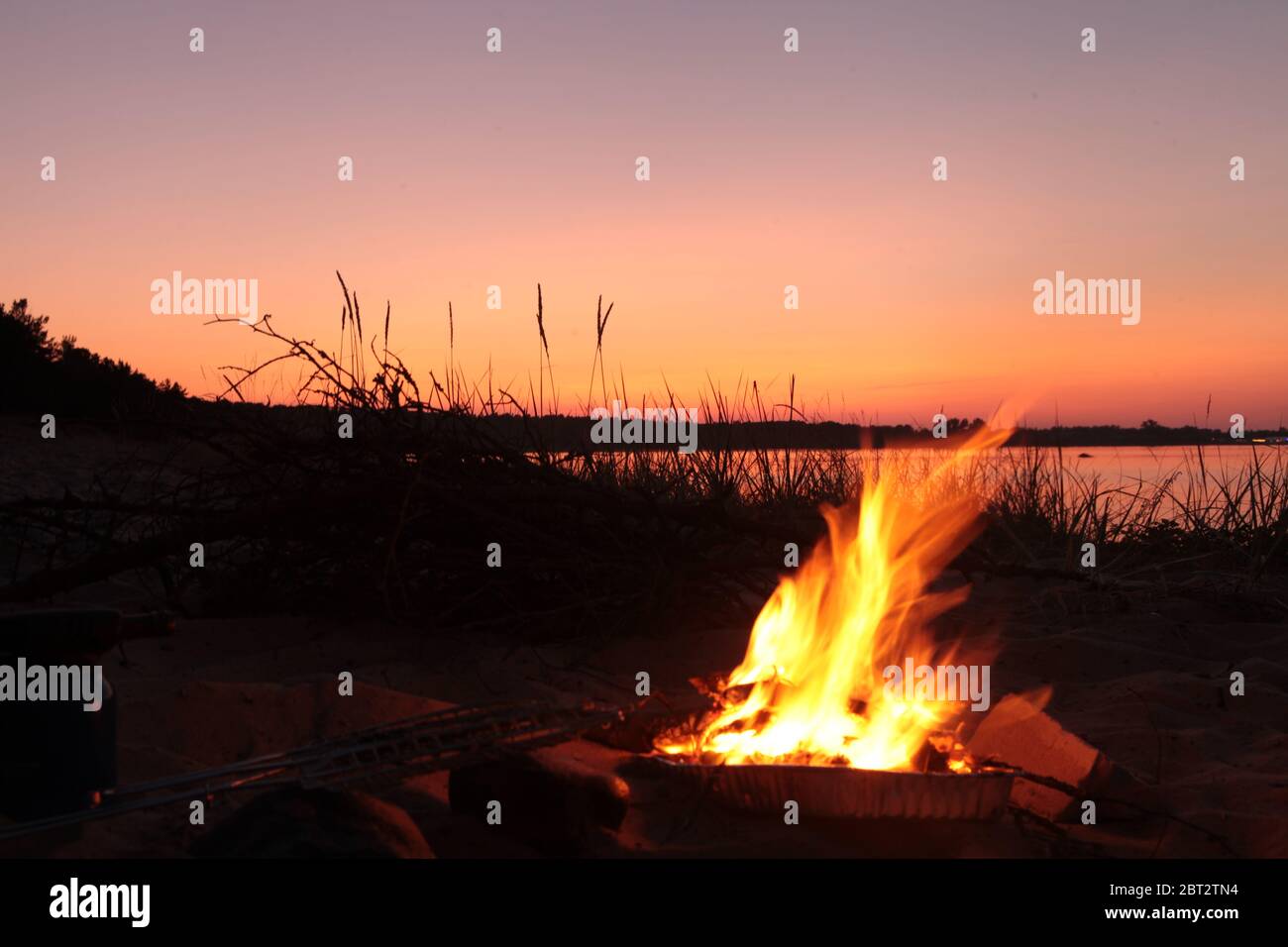 Beach Campfire on Lake. Red sky Superior at sunset as vacation concept Stock Photo