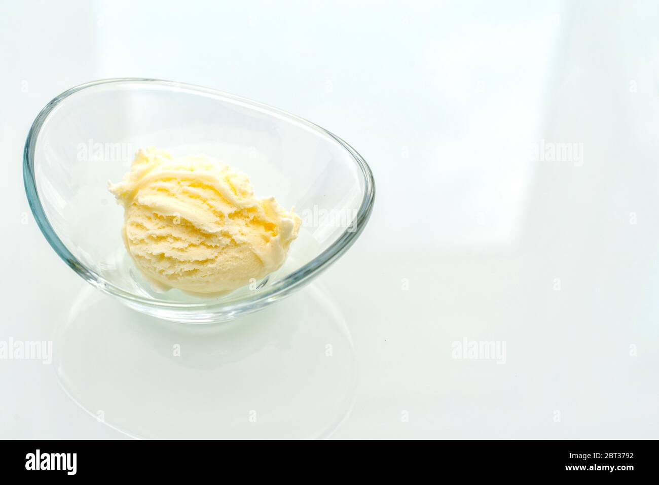 ball of vanilla ice cream in a glass bowl on a light glossy table Stock ...