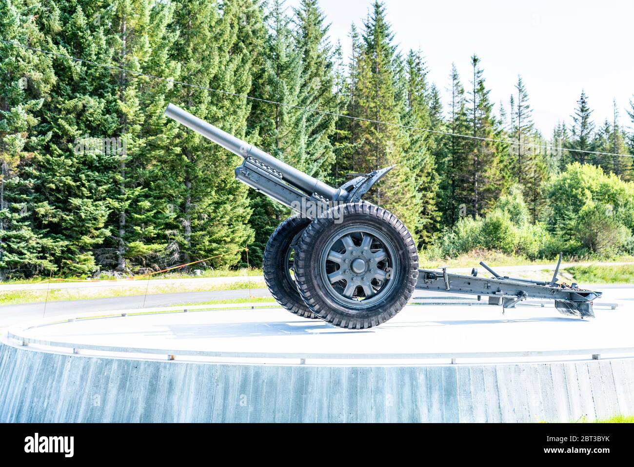 Gronsvik, Norway - August 06, 2019: Side view at artilery gun standing in front of Main building of museum of Gronsvik coastal battery, Helgelandmuseu Stock Photo