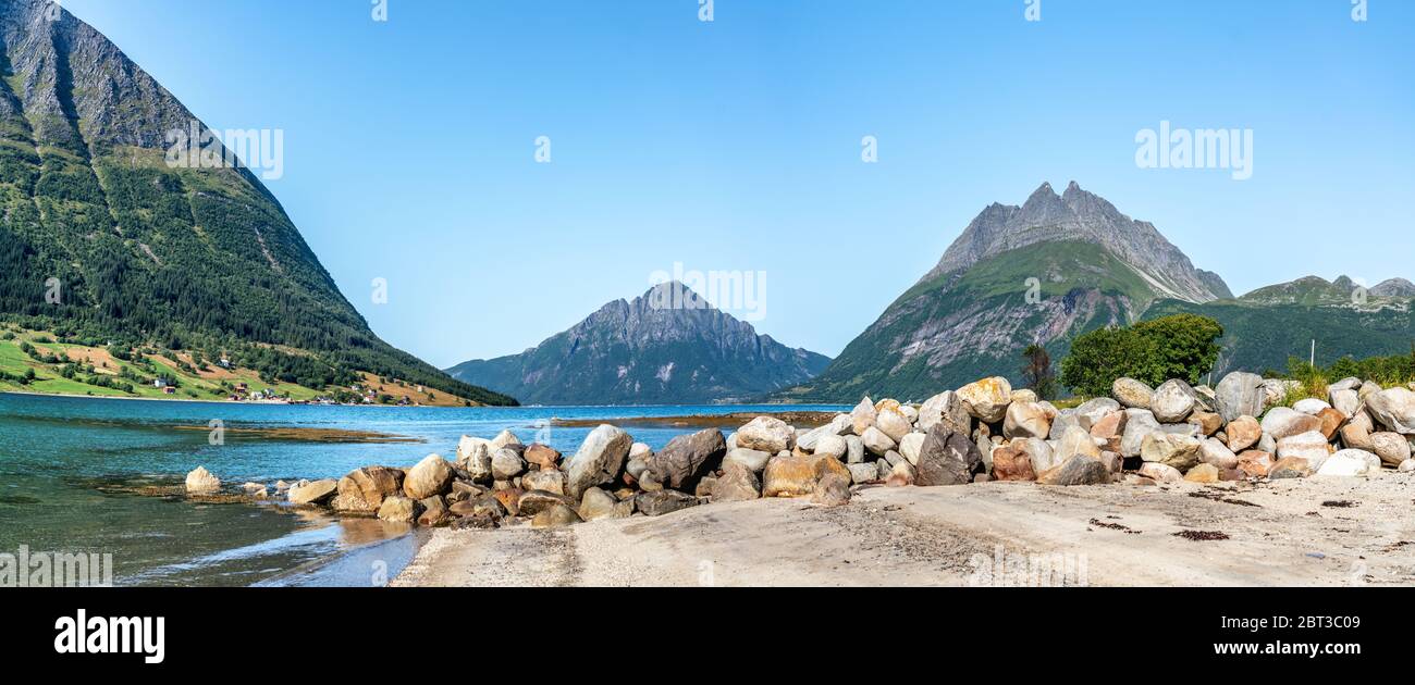 Panoramic view from Luroy at ford with Aldra Island (left), Olvika (center) and some unknown high mountain (left). The wall of heavy stones on sandy b Stock Photo