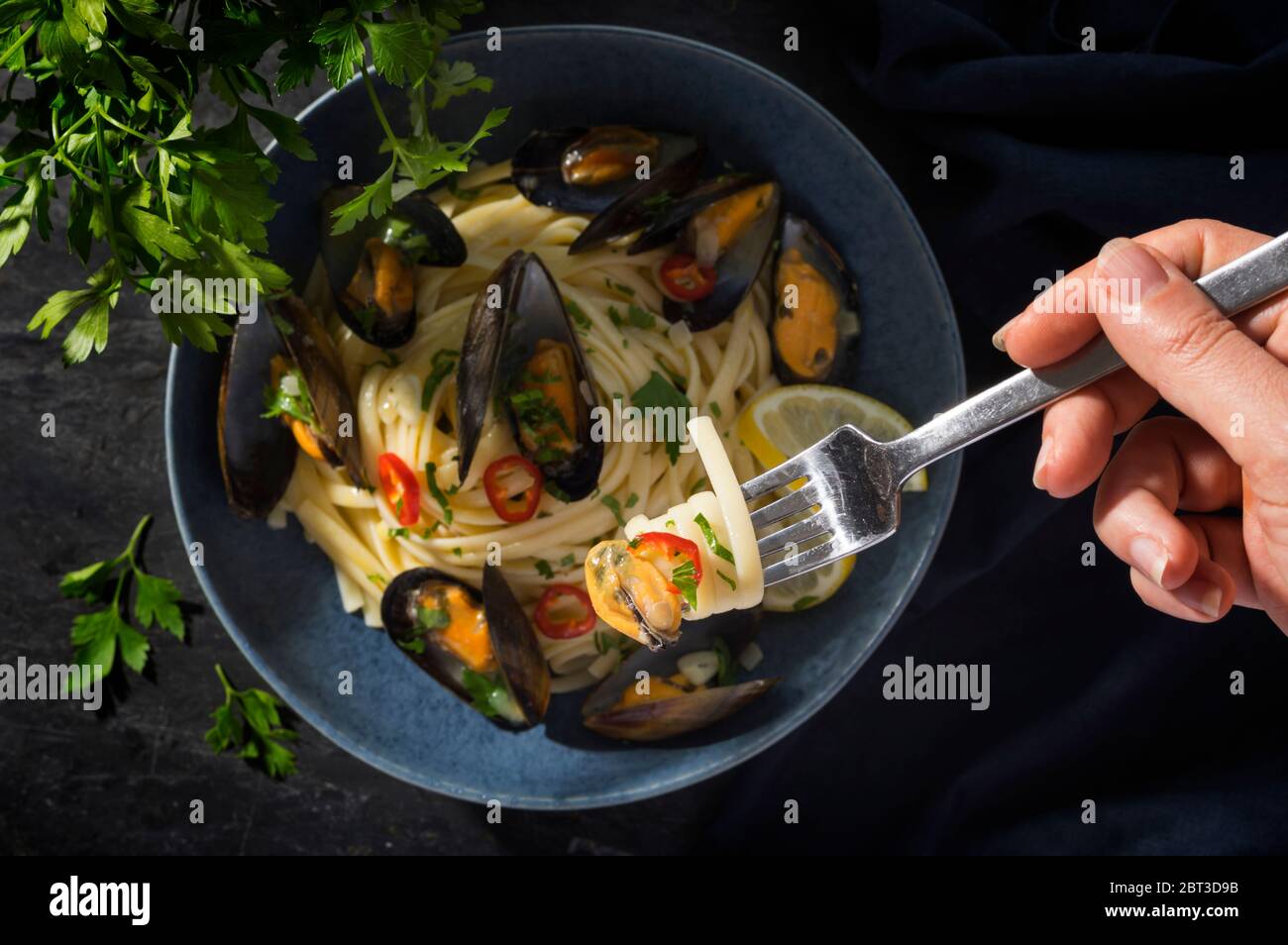 Steamed mussels in linguine pasta in white wine sauce with garlic