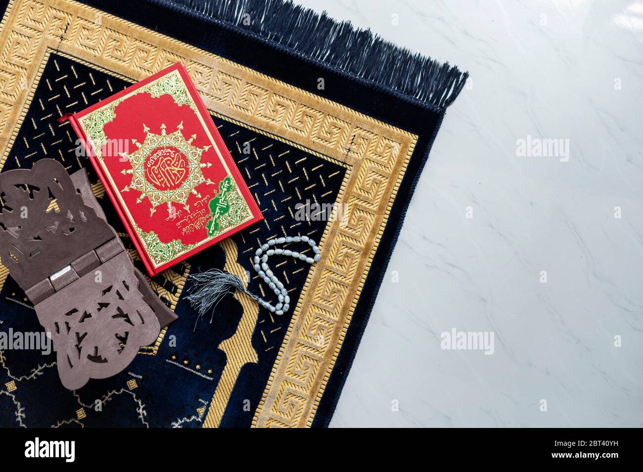 Muslim Holy Quran and rosary or tasbih with praying mat rug or sejadah