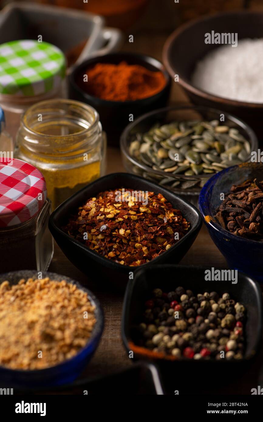 Different shape of bowls in different kind of spices on a wooden table Stock Photo