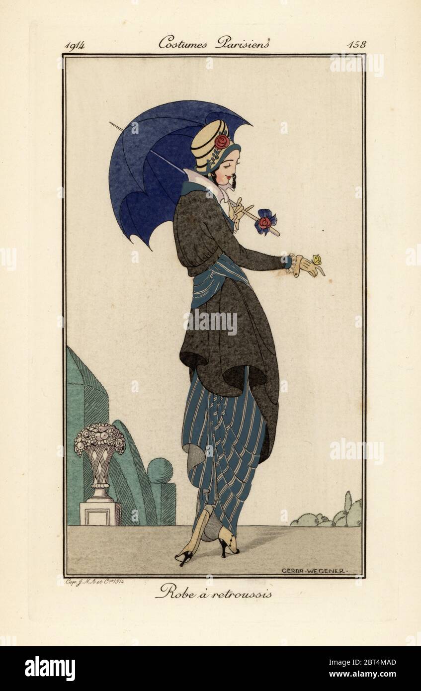 Woman in ruched dress and coat with hat and parasol looking at a butterfly on her hand. Robe a retroussis. Handcoloured pochoir (stencil) etching after an illustration by Gerda Wegener from Tommaso Antonginis Journal des Dames et des Modes, Aux Bureaux du Journal des Dames, Paris, 1914. Stock Photo