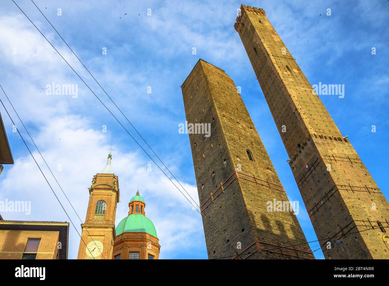 Perspective bottom view of Two Towers of Bologna, symbol of city in blue sky, Italy. Asinelli tower and Garisenda tower in historic downtown with Stock Photo