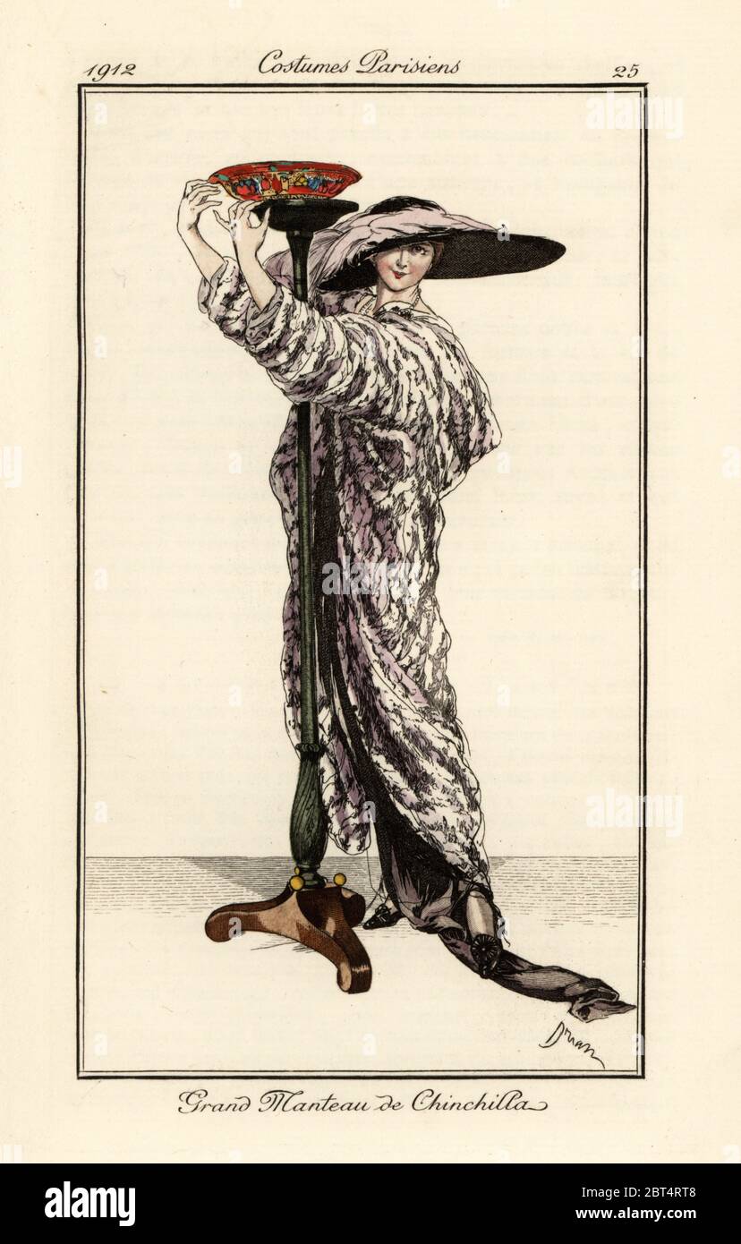 Woman in long coat of chincilla fur, wide brimmed hat with feathers, fixing a lampstand. Grand manteau de chinchilla. Handcoloured pochoir (stencil) etching after an illustration by Adrien Etienne Drian from Tommaso Antonginis Journal des Dames et des Modes, Aux Bureaux du Journal des Dames, Paris, 1912. Stock Photo