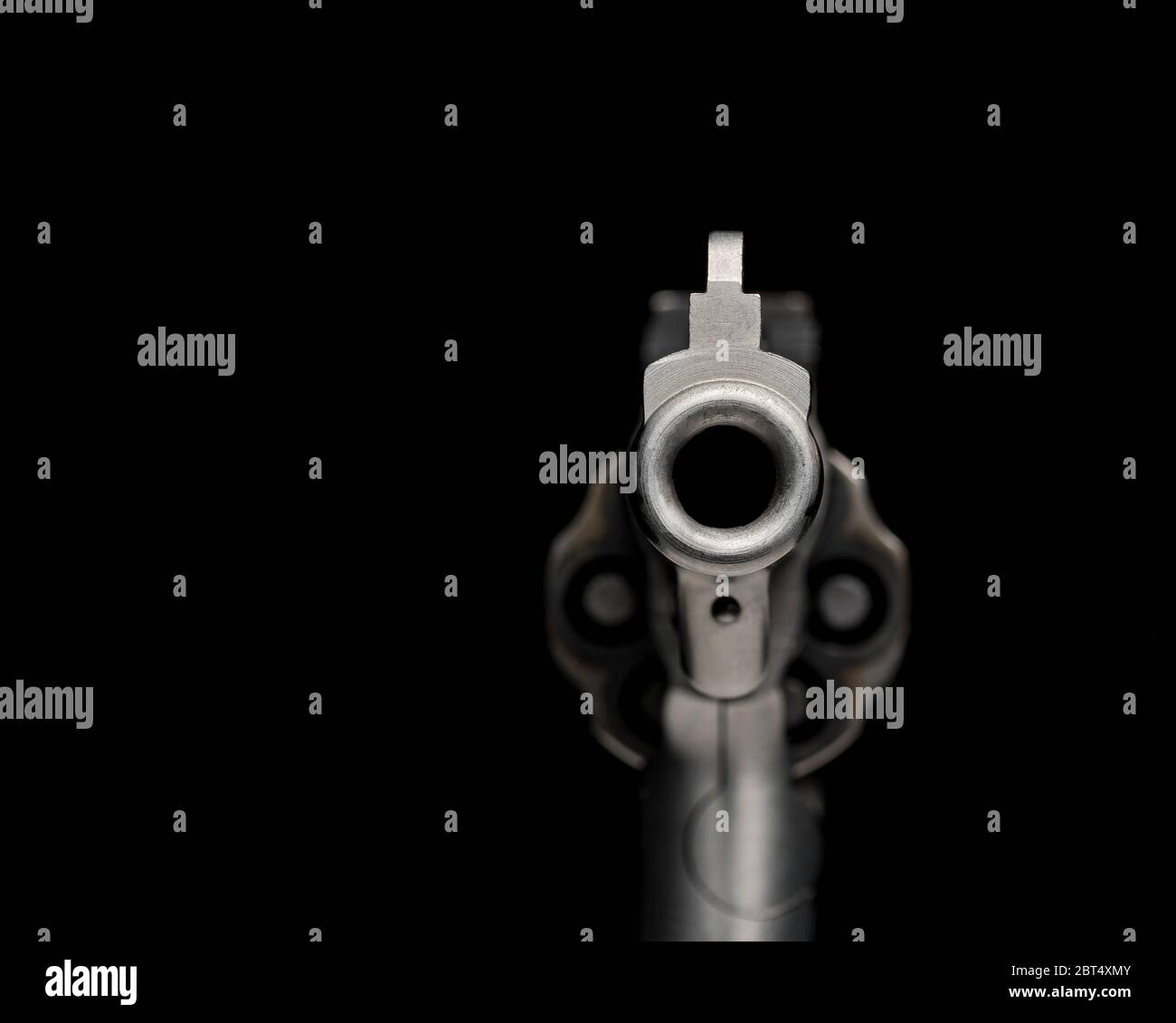 Looking down barrel of gun, pointed toward you, isolated on black background. Concept of crime, violence, shooting, firearm control and safety Stock Photo