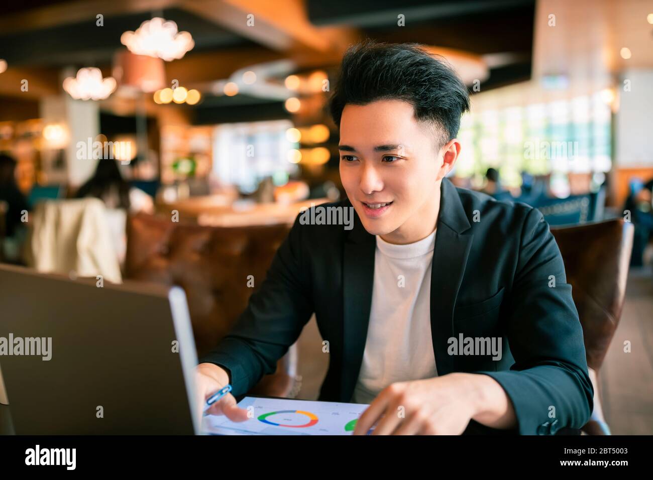 young Business man  Working On Laptop In Coffee Shop Stock Photo