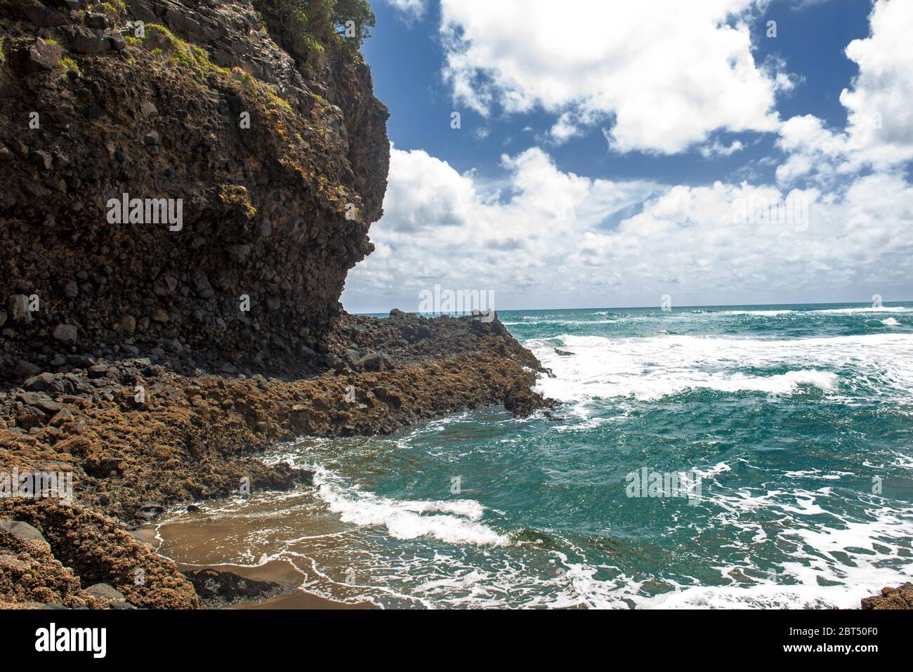 Seascape of a cliff near the ocean under a blue sky with clouds Stock Photo
