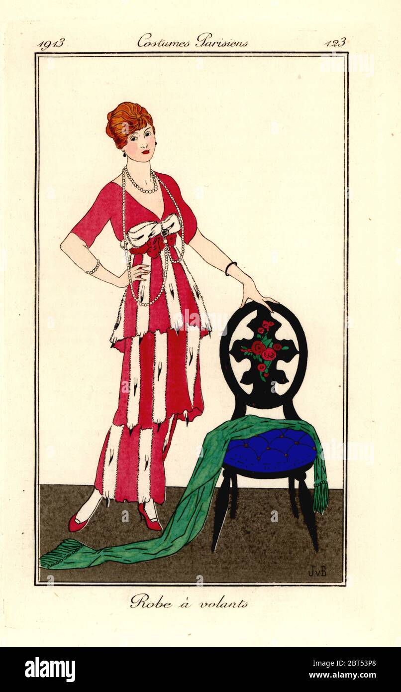 Woman in dress with ermine ruffles standing next to a chair. Robe a volants. Handcoloured pochoir (stencil) etching after an illustration by Jan van Brock from Tommaso Antonginis Journal des Dames et des Modes, Aux Bureaux du Journal des Dames, Paris, 1913. Stock Photo