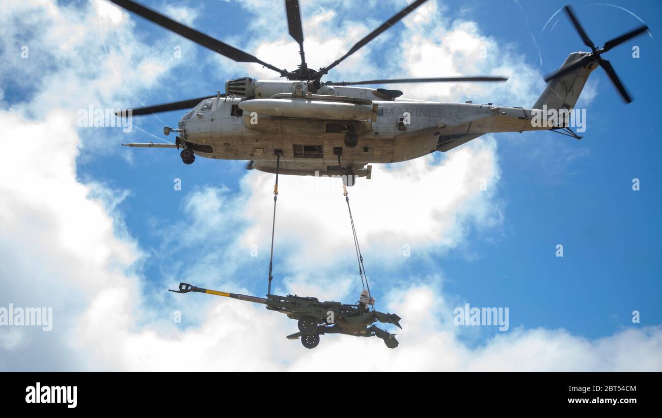 U.S. Marine Corps CH-53E Super Stallion helicopter with Marine Heavy Helicopter Squadron 463 lifts the M777 Howitzer during a hoist lift exercise on Marine Corps Base Hawaii, May 21, 2020. HMH-463 worked with 1st Battalion, 12th Marines and Combat Logistics Battalion 3 to increase proficiency and combat readiness. (U.S. Marine Corps photo by Cpl. Eric Tso) Stock Photo