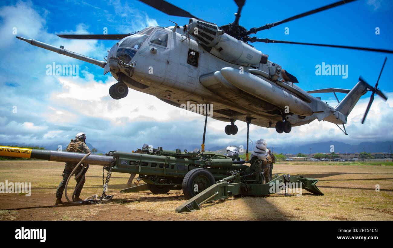 U.S. Marine Corps CH-53E Super Stallion helicopter with Marine Heavy Helicopter Squadron 463 prepares to lift the M777 Howitzer during a hoist lift exercise on Marine Corps Base Hawaii, May 21, 2020. HMH-463 worked with 1st Battalion, 12th Marines and Combat Logistics Battalion 3 to increase proficiency and combat readiness.  (U.S. Marine Corps photo by Cpl. Eric Tso) Stock Photo