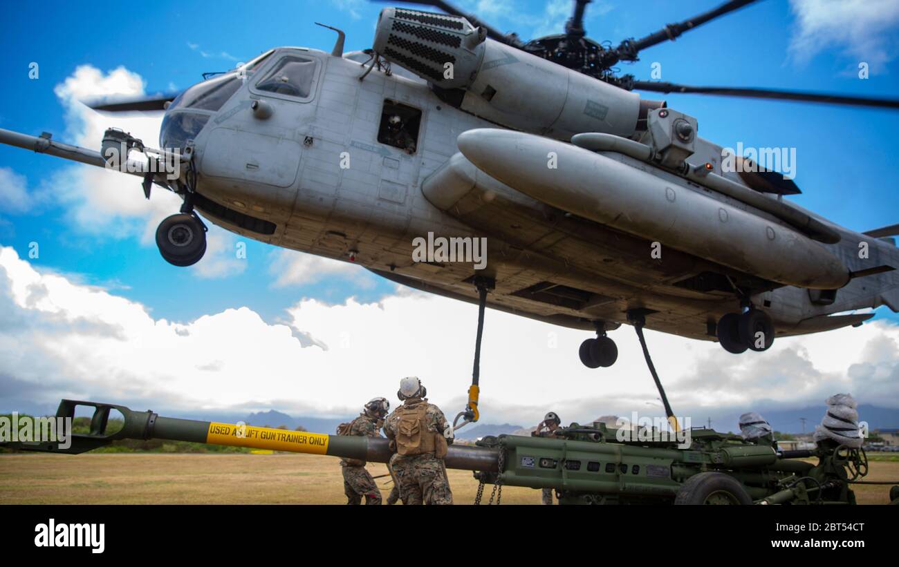 U.S. Marine Corps CH-53E Super Stallion helicopter with Marine Heavy Helicopter Squadron 463 prepares to lift the M777 Howitzer during a hoist lift exercise on Marine Corps Base Hawaii, May 21, 2020. HMH-463 worked with 1st Battalion, 12th Marines and Combat Logistics Battalion 3 to increase proficiency and combat readiness.  (U.S. Marine Corps photo by Cpl. Eric Tso) Stock Photo